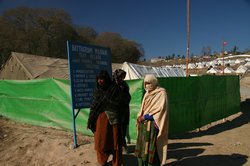 Women gather at the entrance of a tent village